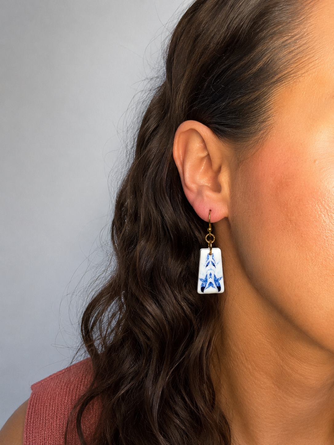 Pendientes Taulell de arcilla polimérica en blanco y azul puestos en la oreja