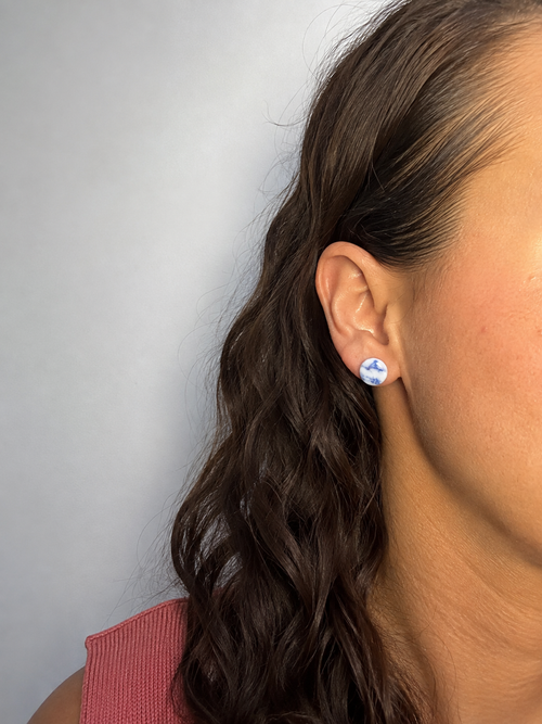 Pendientes Blauet de arcilla polimérica en blanco y azul puestos en la oreja