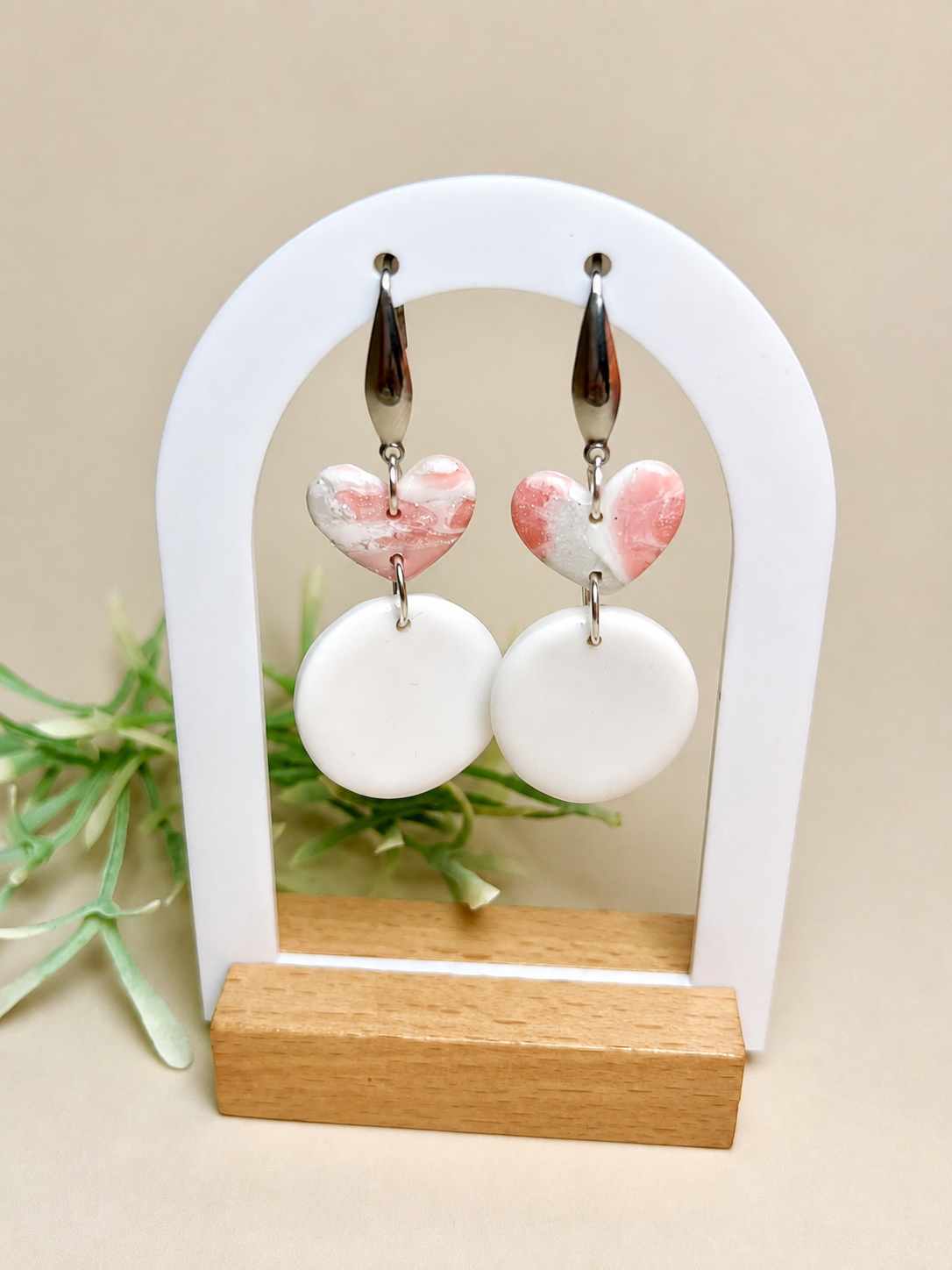 Pendientes Vera de arcilla polimérica en blanco y rosa sobre expositor