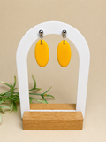 Pendientes Mustard Oval de arcilla polimérica en amarillo sobre expositor