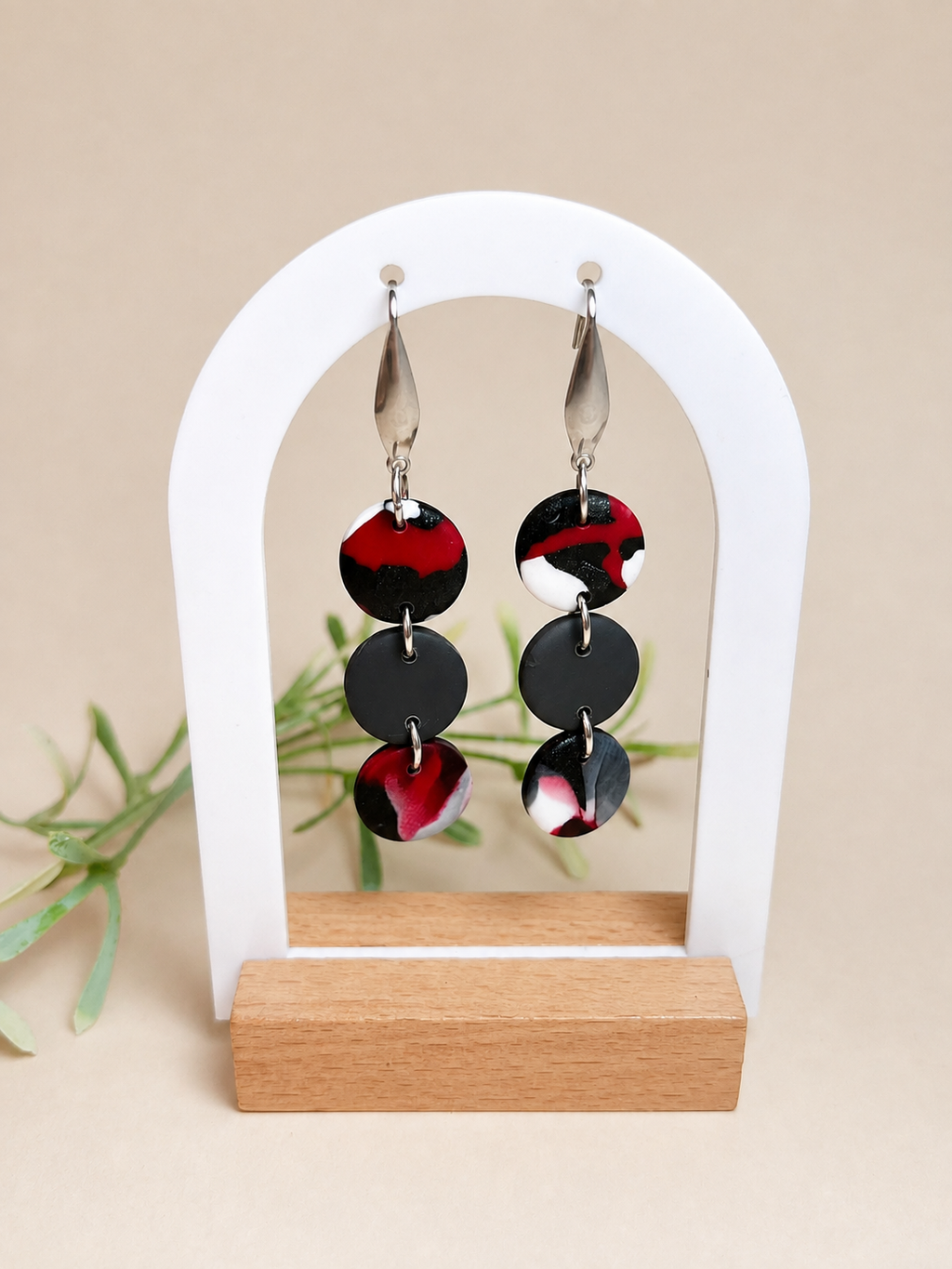 Pendientes Deep Red de arcilla polimérica en blanco, rojo y negro sobre expositor