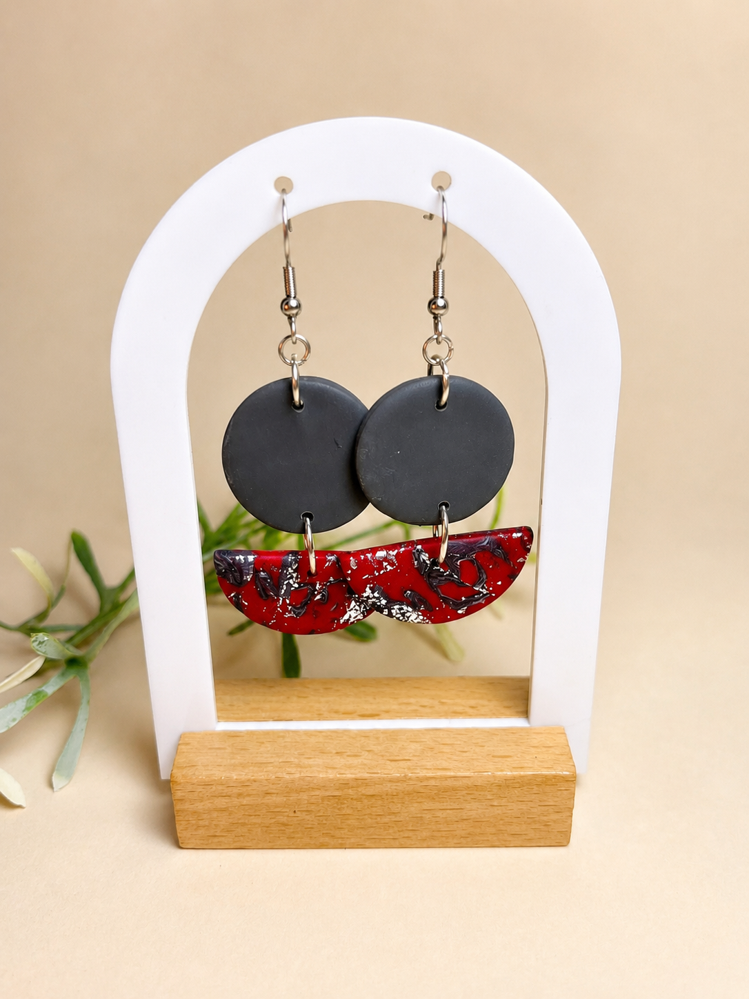 Pendientes Red One de arcilla polimérica en rojo y gris sobre expositor