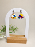 Pendientes Festa de arcilla polimérica en blanco y multicolor sobre expositor