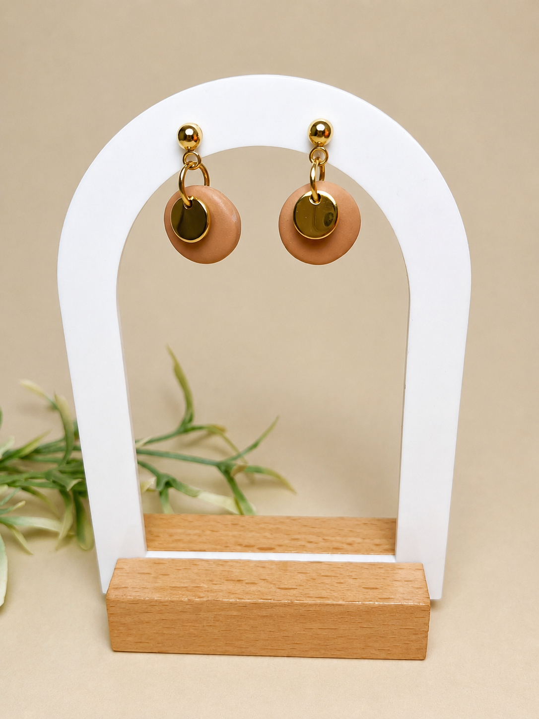 Pendientes Brillo de arcilla polimérica en dorado y beige sobre expositor