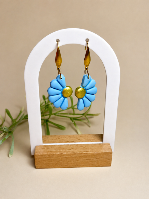 Pendientes Camelia Azul de arcilla polimérica en azul sobre expositor
