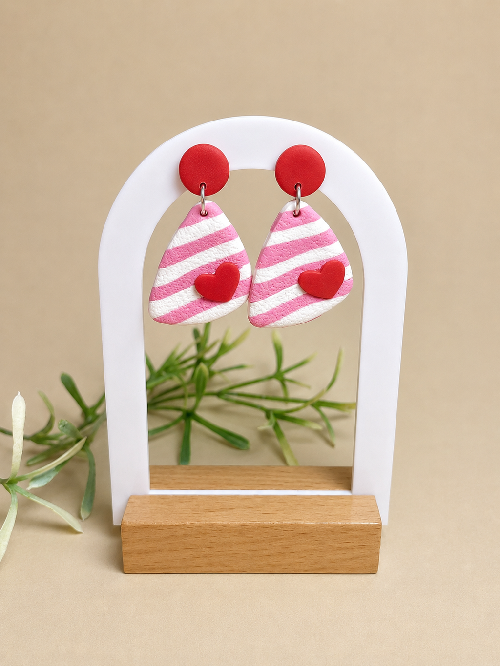 Pendientes Love Pop de arcilla polimérica en rosa, blanco y rojo sobre expositor
