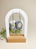 Pendientes Mist Ring de arcilla polimérica en gris y blanco sobre expositor