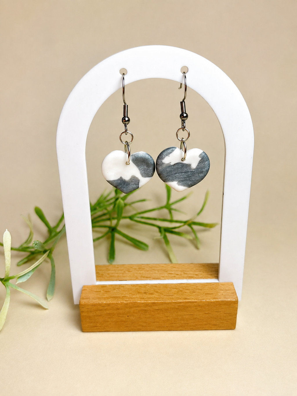 Pendientes Mist Heart de arcilla polimérica en blanco y plateado sobre expositor