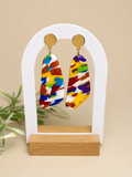 Pendientes Flow de arcilla polimérica en blanco, amarillo, rojo, naranja, verde y azul sobre expositor