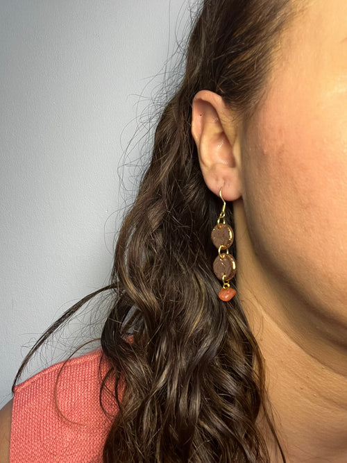 Pendientes Choco Drops de arcilla polimérica en marrón y dorado puestos en la oreja