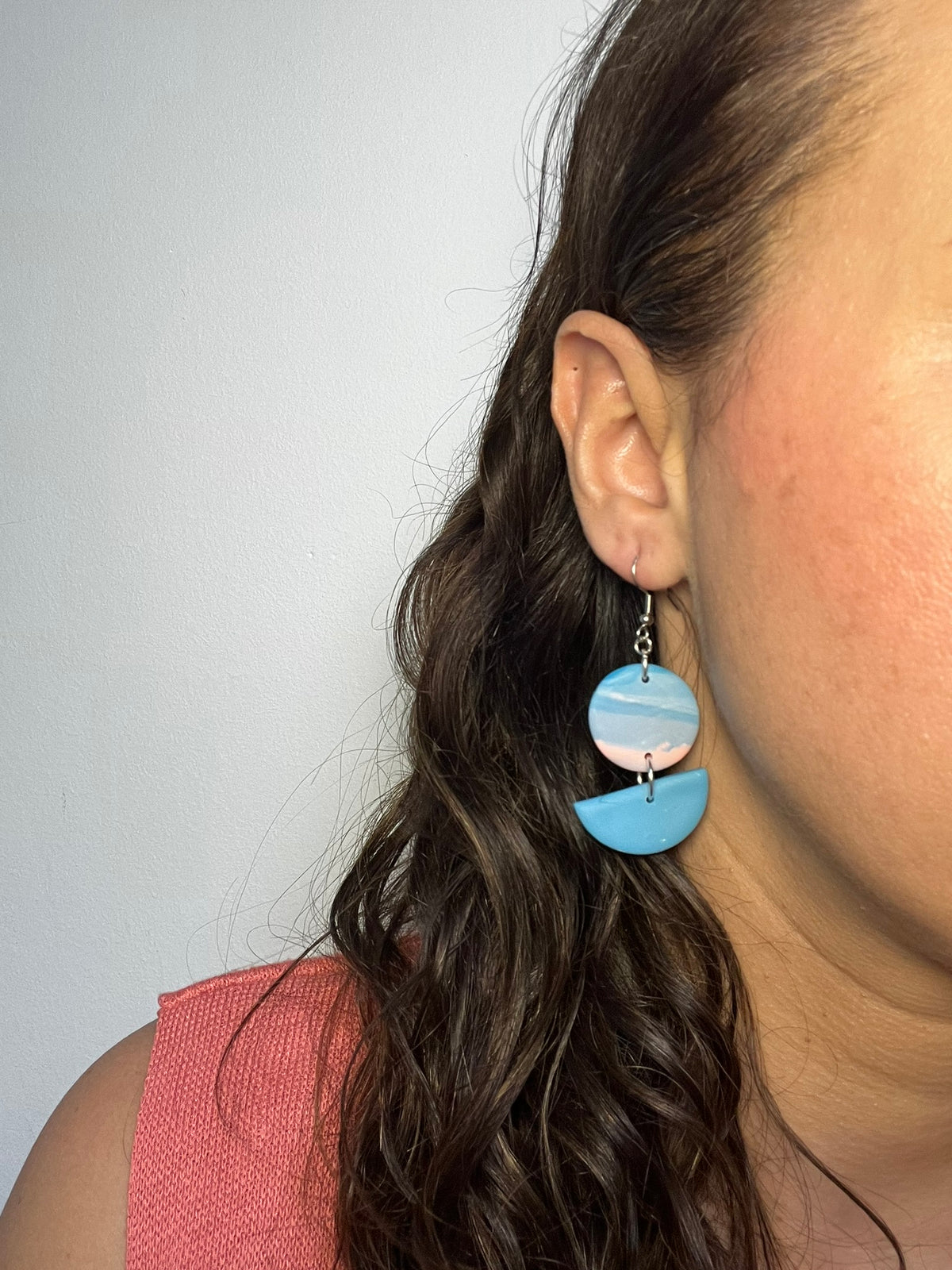 Pendientes Sky de arcilla polimérica en azul y rosa puestos en la oreja