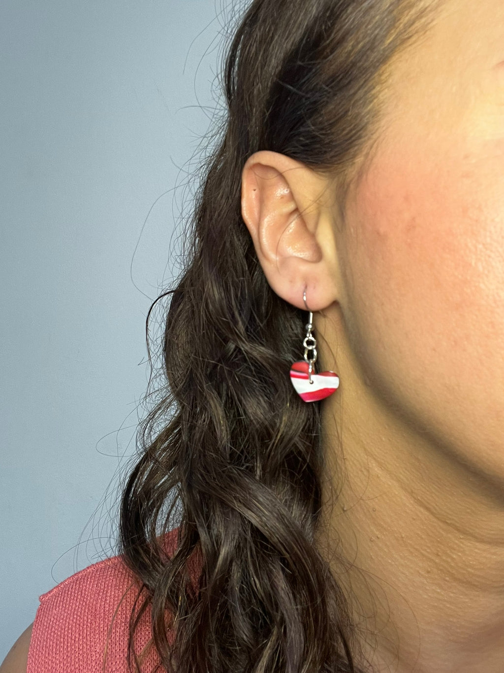 Pendientes Red Heart de arcilla polimérica en rojo, blanco y negro puestos en la oreja
