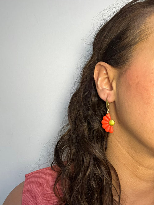 Pendientes Camelia Naranja de arcilla polimérica en naranja puestos en la oreja