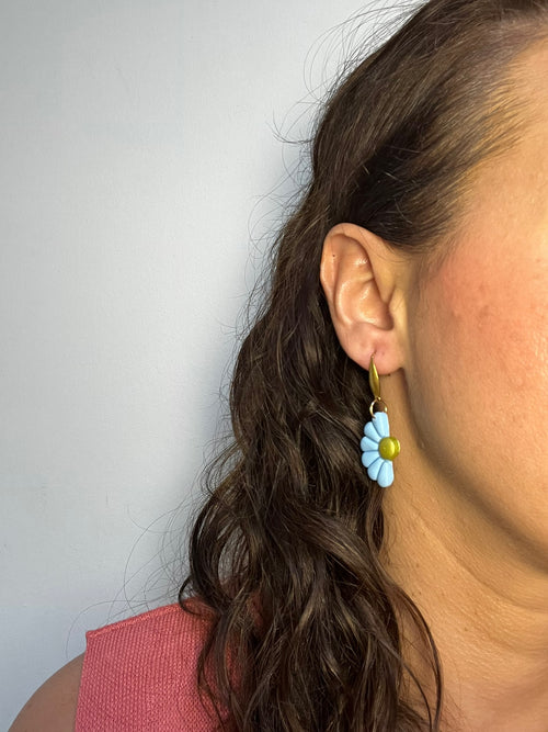 Pendientes Camelia Azul de arcilla polimérica en azul puestos en la oreja