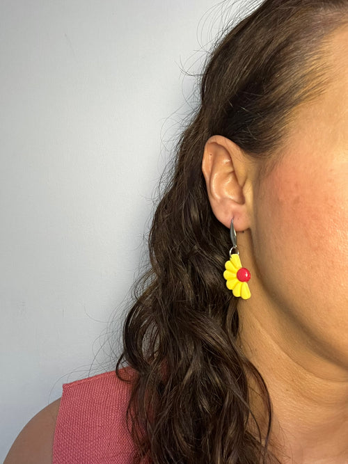 Pendientes Camelia Amarilla de arcilla polimérica en amarillo puestos en la oreja