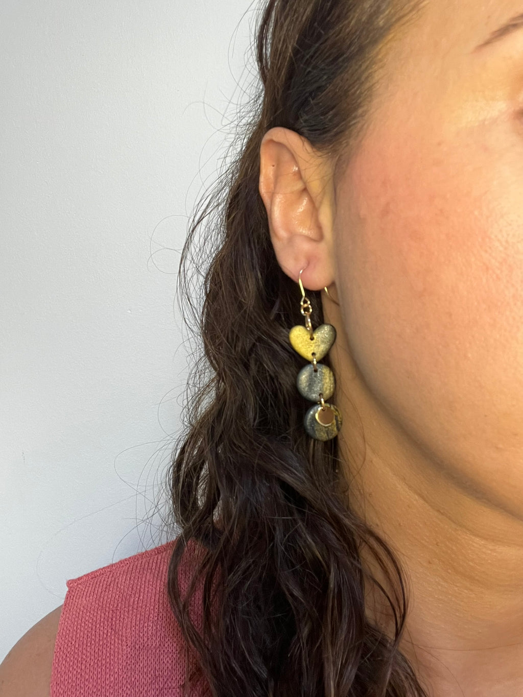 Pendientes Eclipse de arcilla polimérica en negro y dorado puestos en la oreja