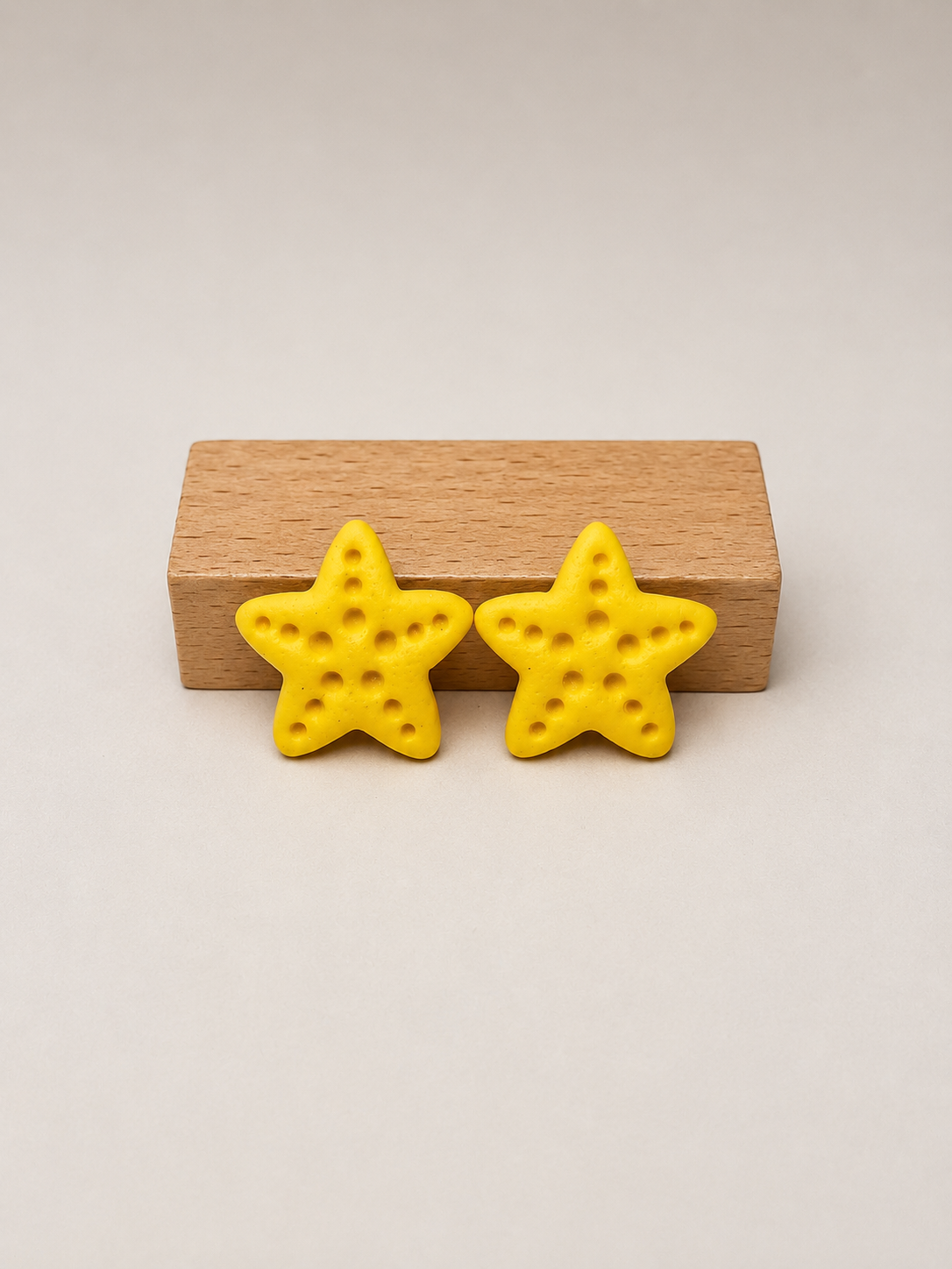 Pendientes Estrella Amarilla de arcilla polimérica en amarillo sobre expositor