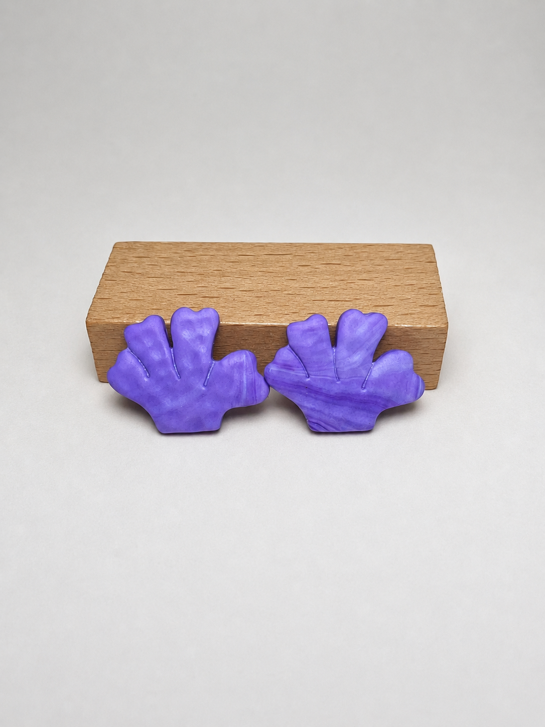 Pendientes Coral Morado de arcilla polimérica en purpura sobre expositor